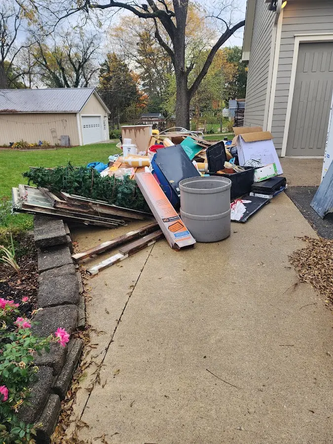Dumpster being loaded with debris for Estate Cleanout Dumpster Rental in Oak Island